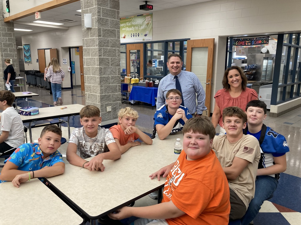 Image includes students during their lunch period smiling bit for the First day of school