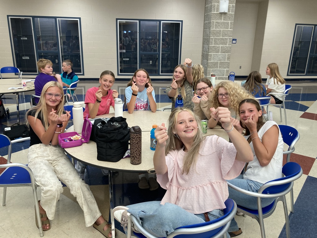 Image includes students during their lunch period smiling bit for the First day of school