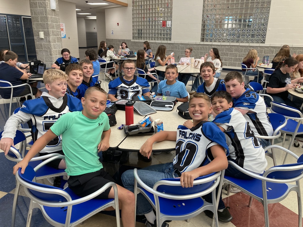Image includes students during their lunch period smiling bit for the First day of school