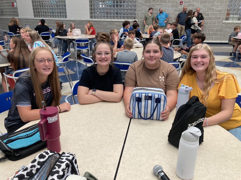 Image includes students during their lunch period smiling bit for the First day of school