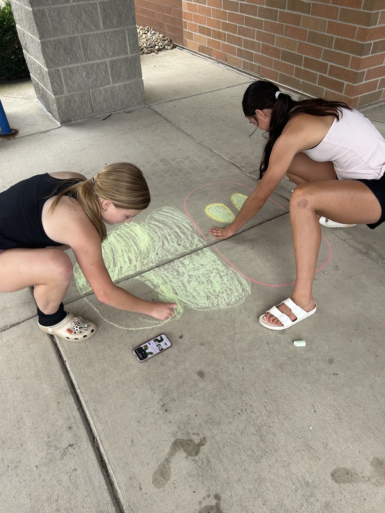 Riverdale Girls Highschool Soccer Team create chalk drawings at the student entrances to bring in the new school year with pride and fun.