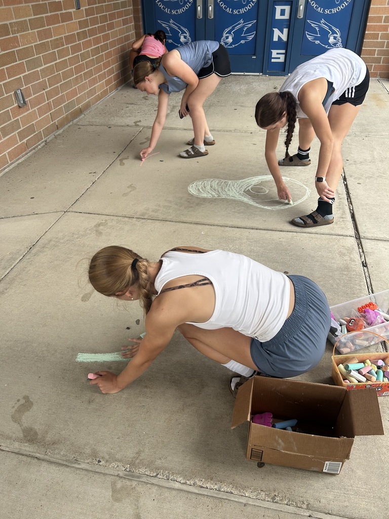 Riverdale Girls Highschool Soccer Team create chalk drawings at the student entrances to bring in the new school year with pride and fun.