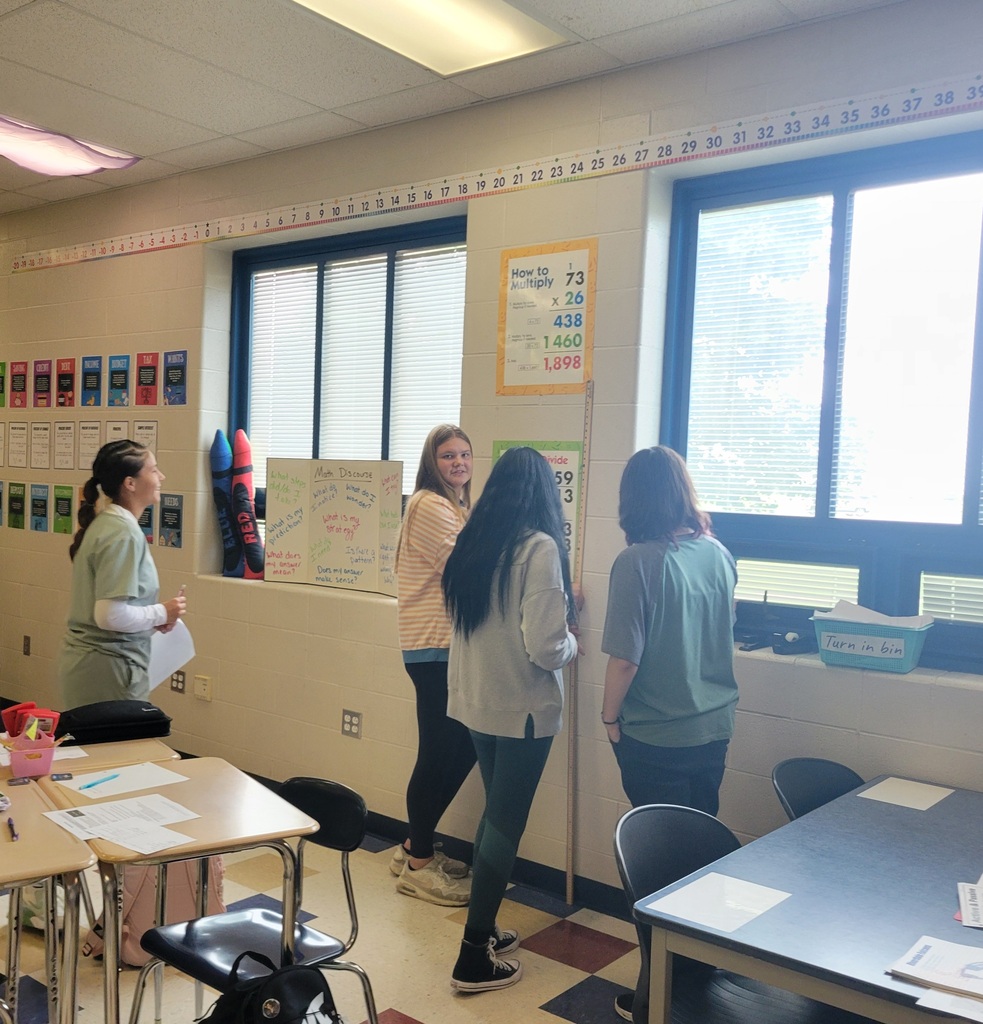 Students measuring the height of the room.