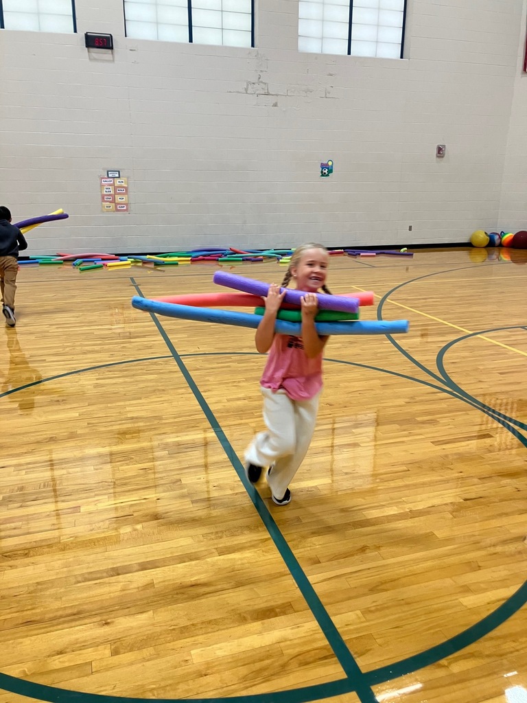 1st grade students in the gym collecting pool noodles