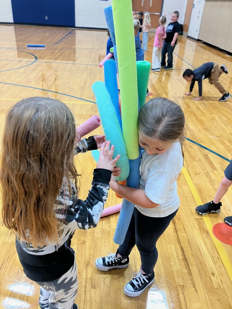 1st grade students in the gym collecting pool noodles