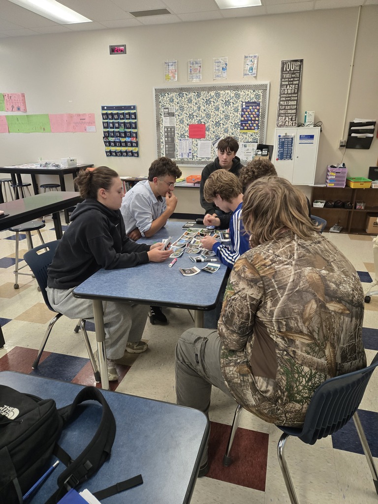 group of students explaining trophies cascades with cards and markers
