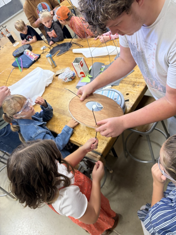 Elementary students helping HS robotics students build ROOMBA Halloween robots into ghosts/brooms/spiders