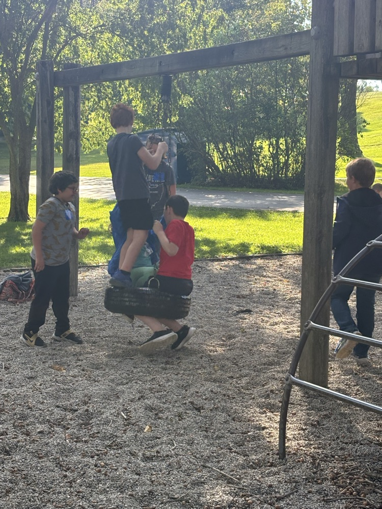 students on the tire swing at the playground