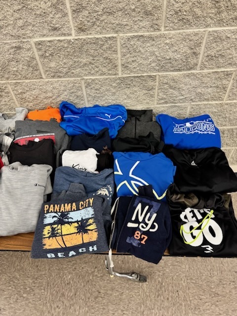 pictures of the lost and found table. sweatshirts, tshirts and lunch bags.