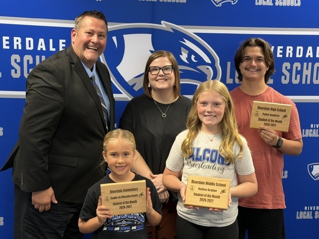 Students and staff member of the moth standing with the superintendent