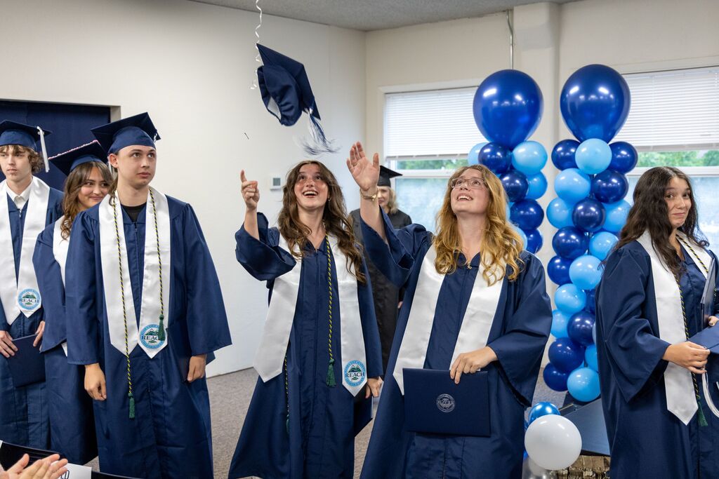 Graduating seniors throw their caps in the air. 