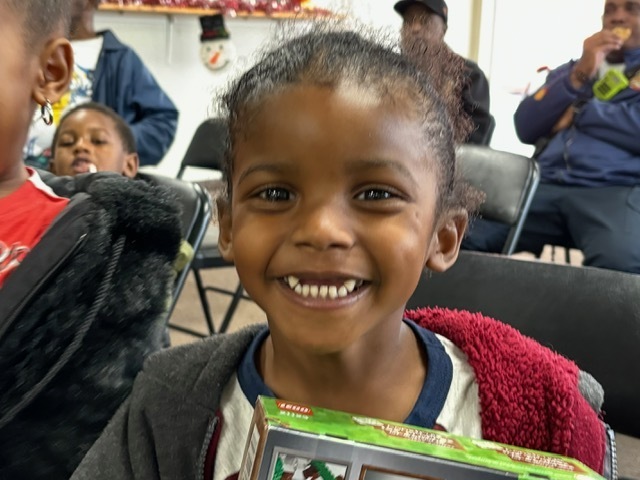 Little girl smiling with a gift in hand