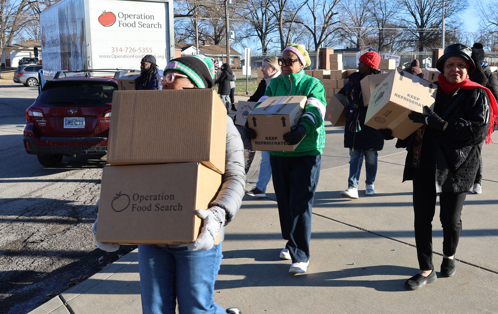 Workers and volunteers carrying boxes of food to distribute to needy families