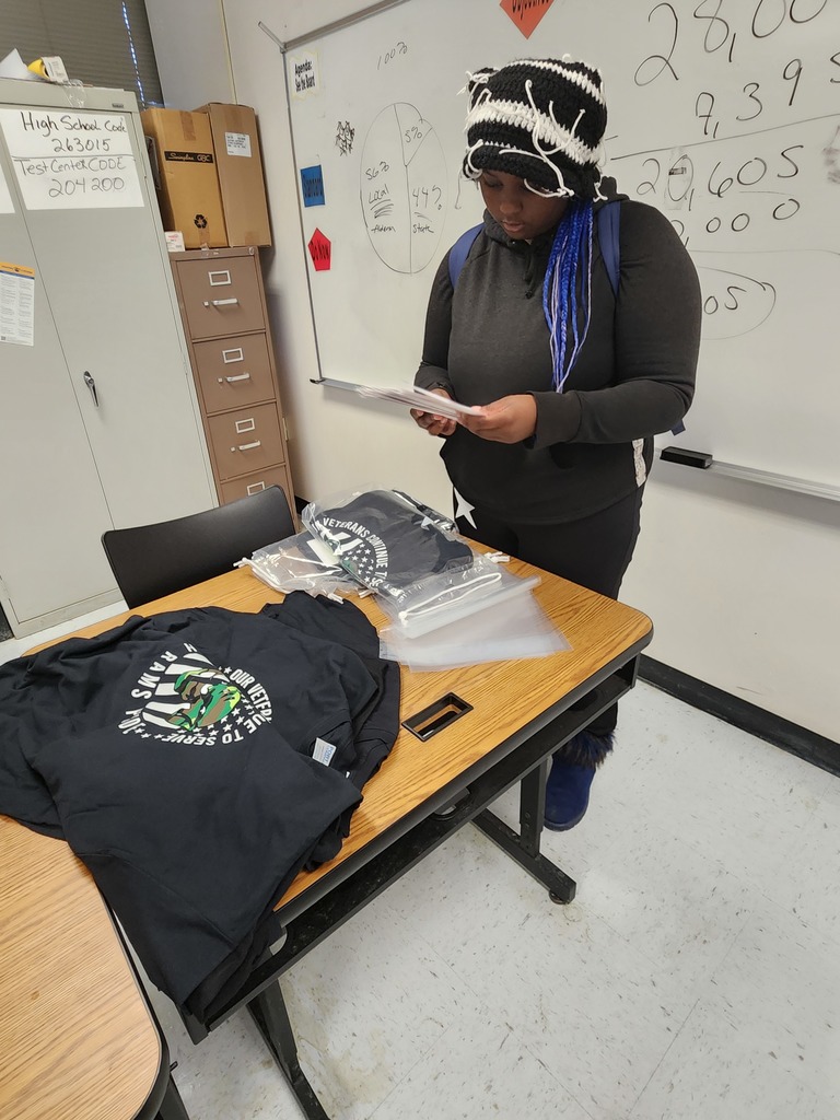 Student placing t-shirt in bag