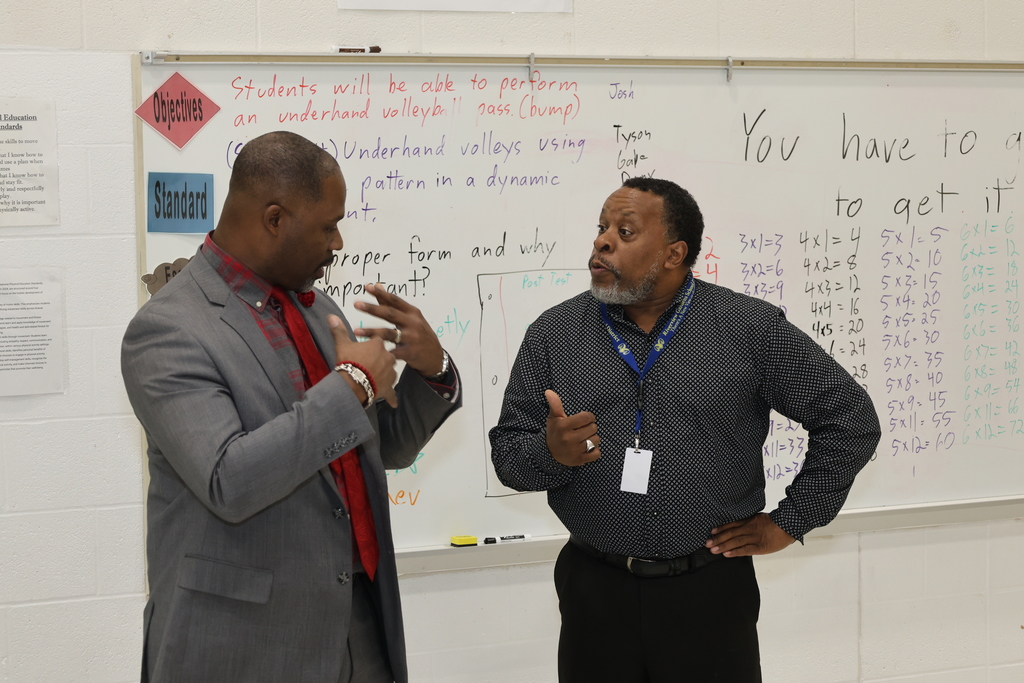 Travis Ford, Sr. having a conversation with Gerald Freeman
