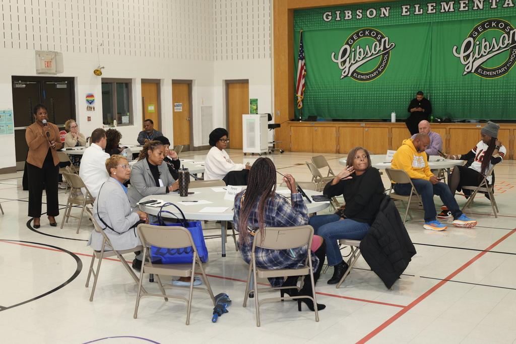 Stakeholders looking at presentation while Dr. Tanya Patton presents information