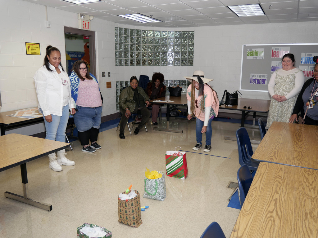 Woman tosses item into gift bag while playing game