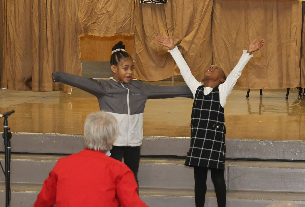 Lewis & Clark students singing and gesturing with arms wide