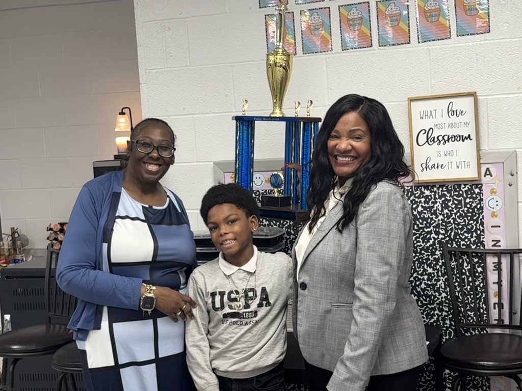 Principal Harris, Malik Henderson, and Ms. Grose celebrating  his achievement 