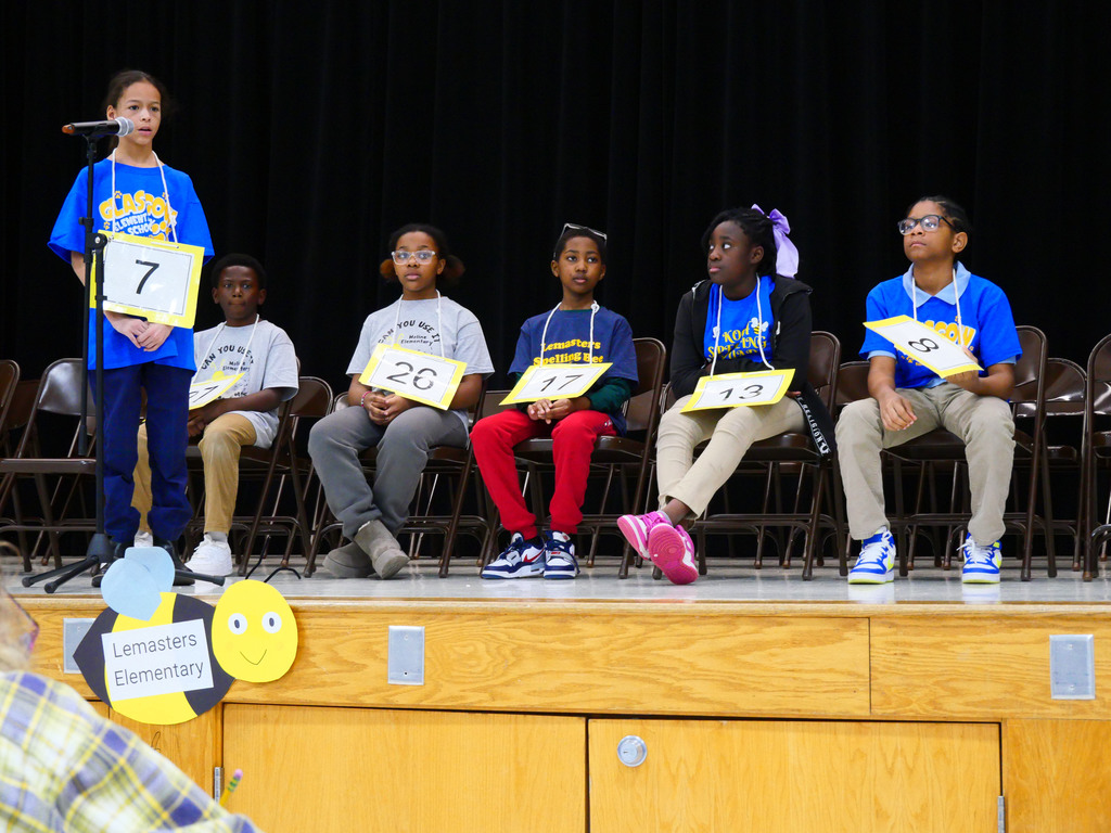 Girl spelling at microphone during spelling bee