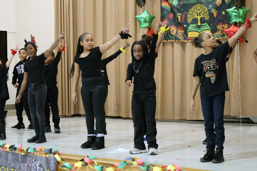 Students performing with hands raised