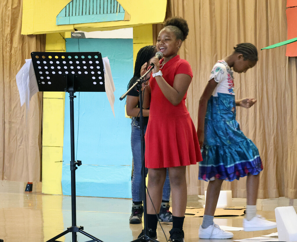 Student in red dress singing