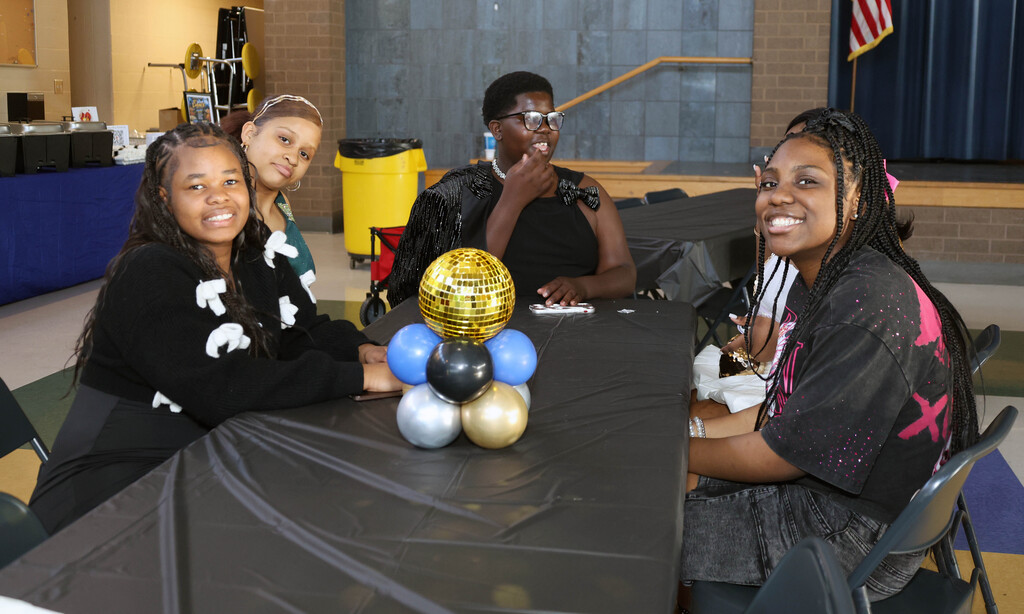 Westview scholars smiling and posting at table