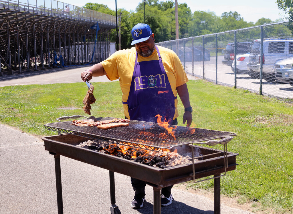 RGHS staff member grilling meat over a hot fire