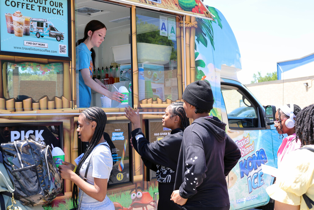 Students getting snow cones from a Kona Ice truck