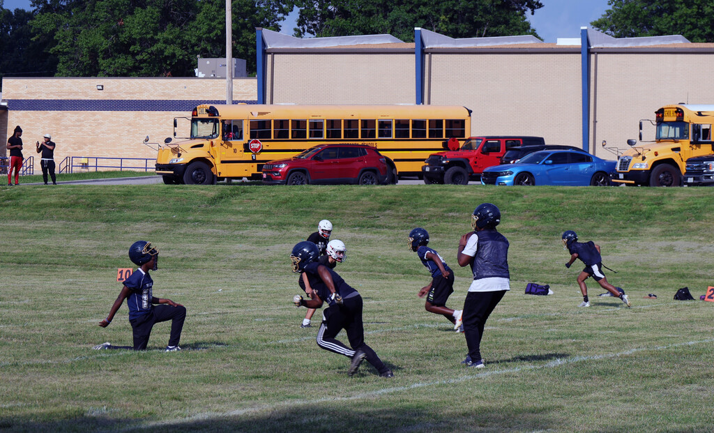 Football drill with quarterback dropping back to pass