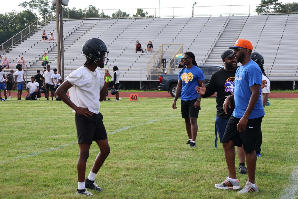 football player talks to coaches