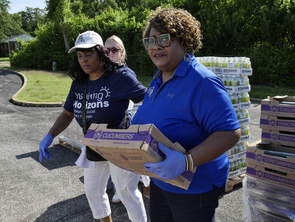Volunteers carrying food to donate to the community