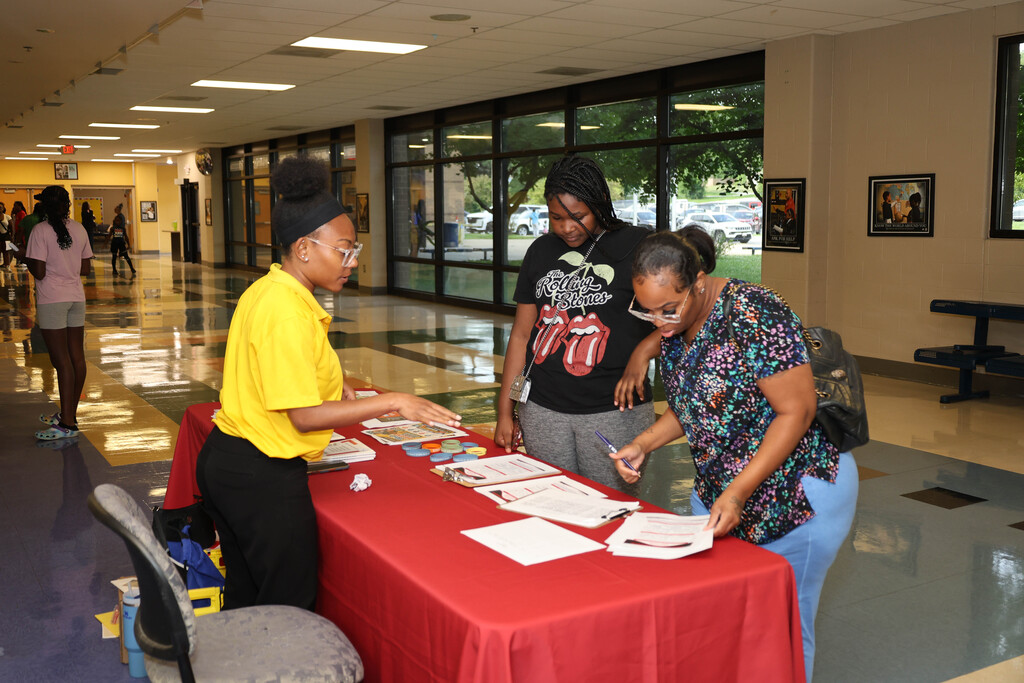 Parent completing form at vendor table