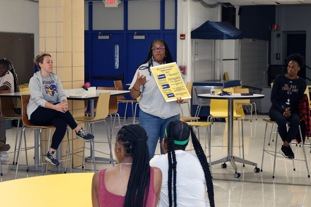 Teacher speaking to students in a cafeteria