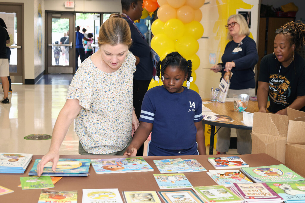 Girl student and teacher looking at books