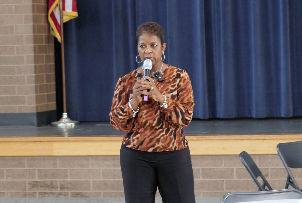 Suprintendent Dr. Tanya Patton speaks to group while holding microphone