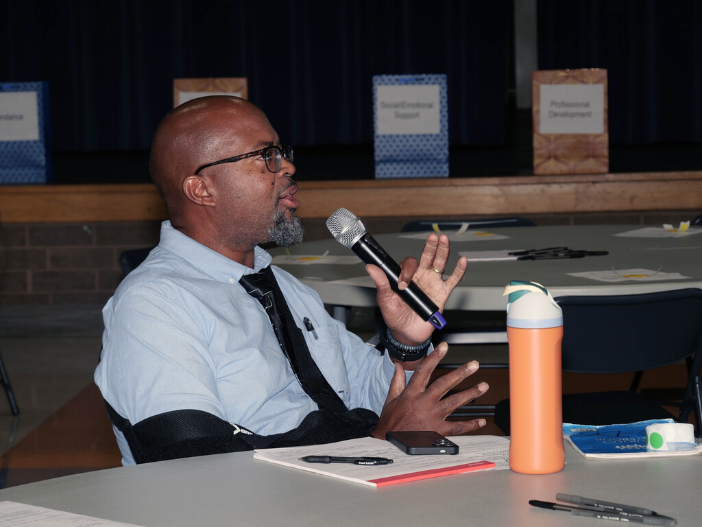 Man speaks into microphone at meeting