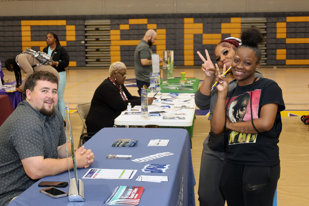 Students talk to college recruiter and pose for photo