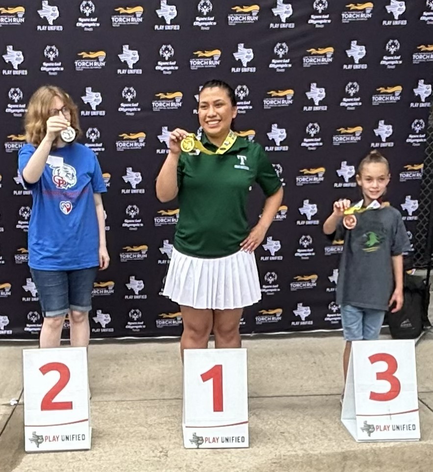 Students from Riviera standing with medal around her neck. She placed third. 
