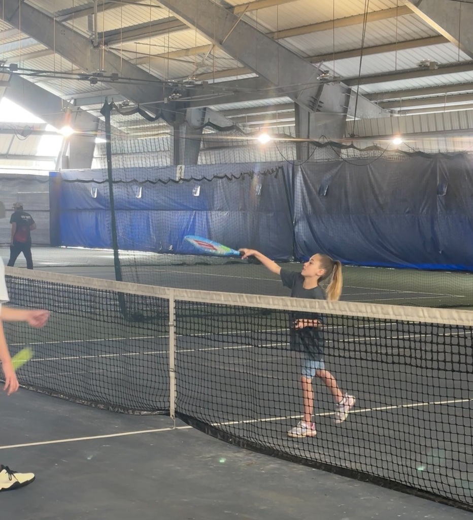 Student in action playing tennis. 