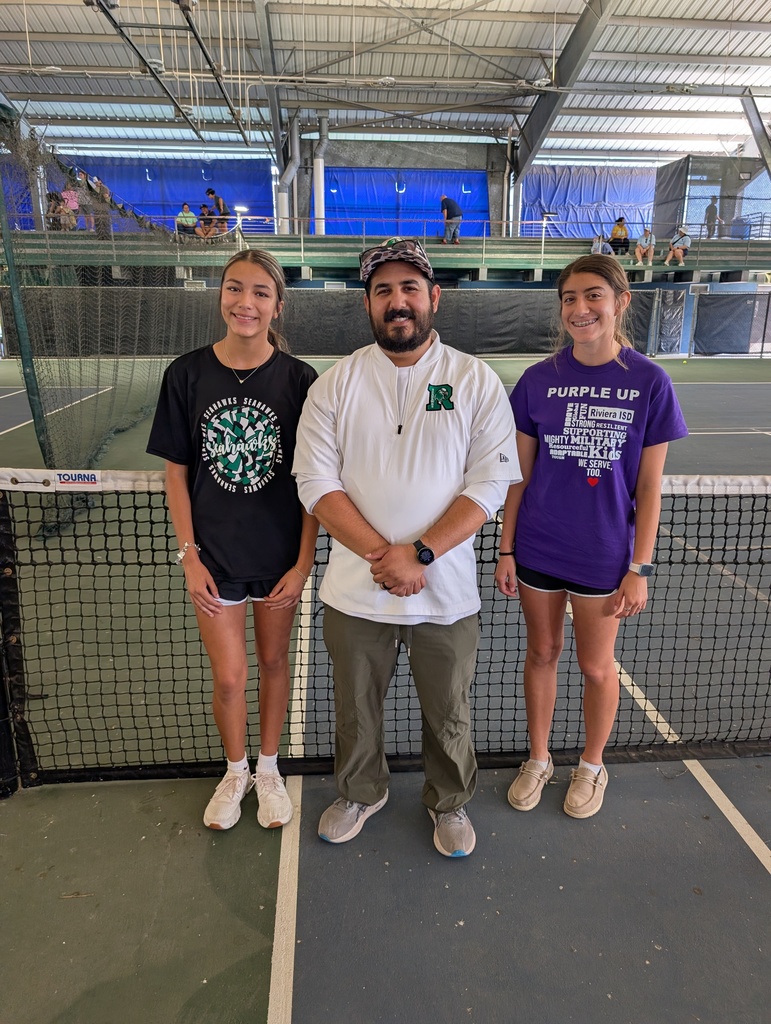 Coach Gonzalez standing with two high school students. 