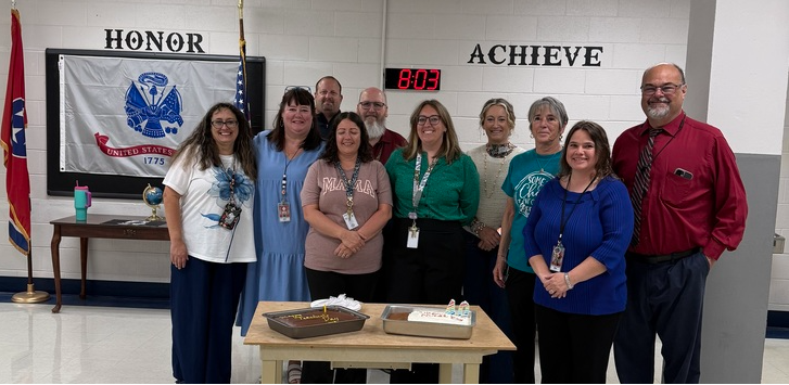 Nurse, teachers, assistants, and principal with cakes