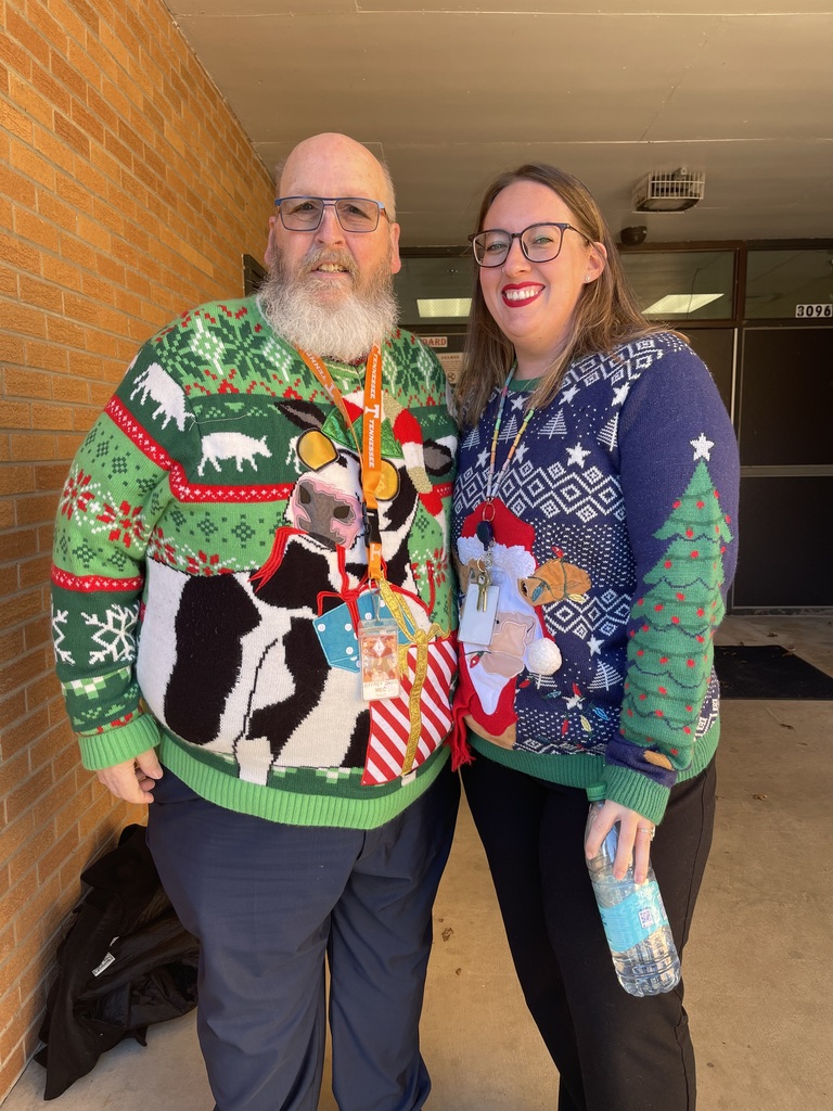 Mr. Davis and Mrs. Welch wearing cow Christmas Sweaters.