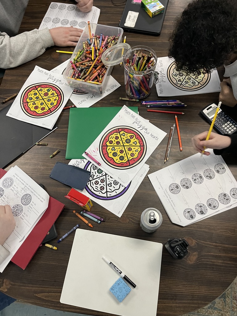 Students working on project with assorted school supplies.