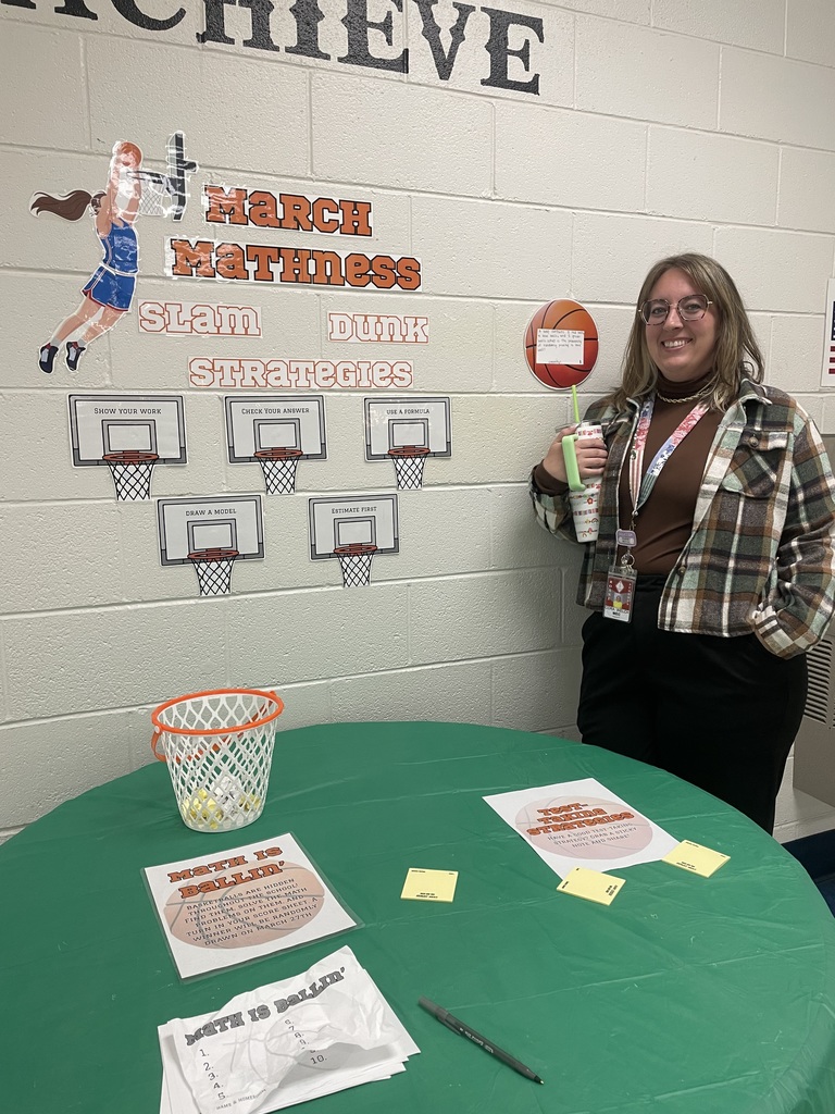Mrs. Welch next to table with "March Mathness" Theme