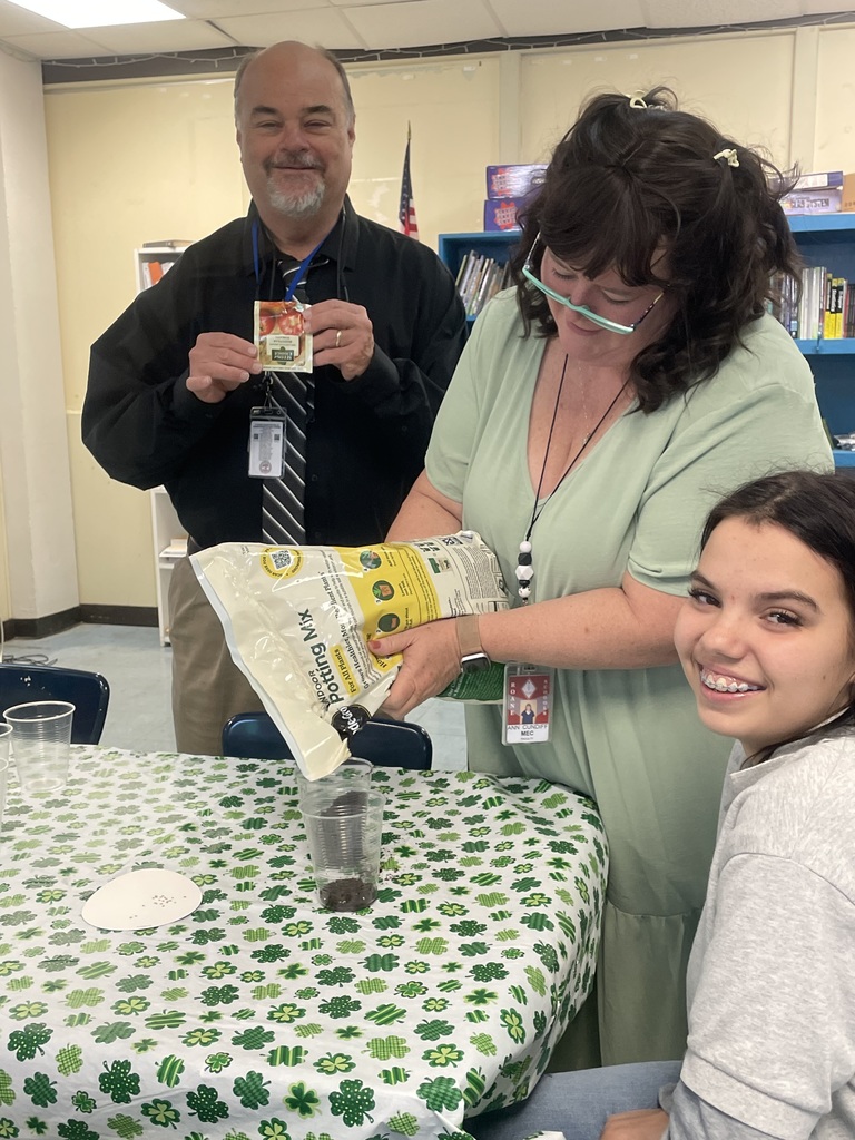 Mr. Johnson and Mrs. Ann helping students get started planting tomato seeds.