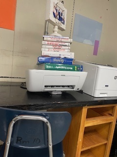 Printer, books, and picture frame on top of index card structure