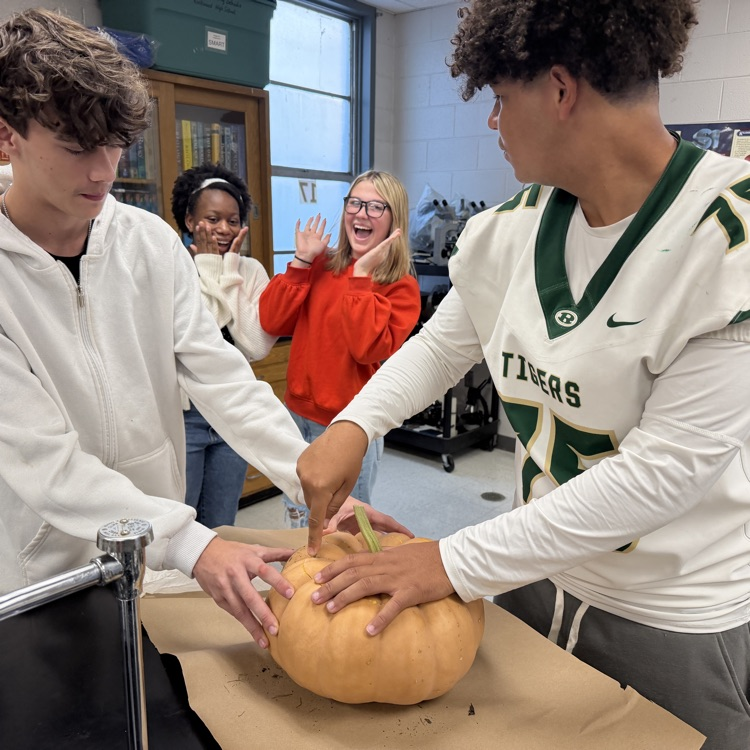 Cutting into their pumpkin 
