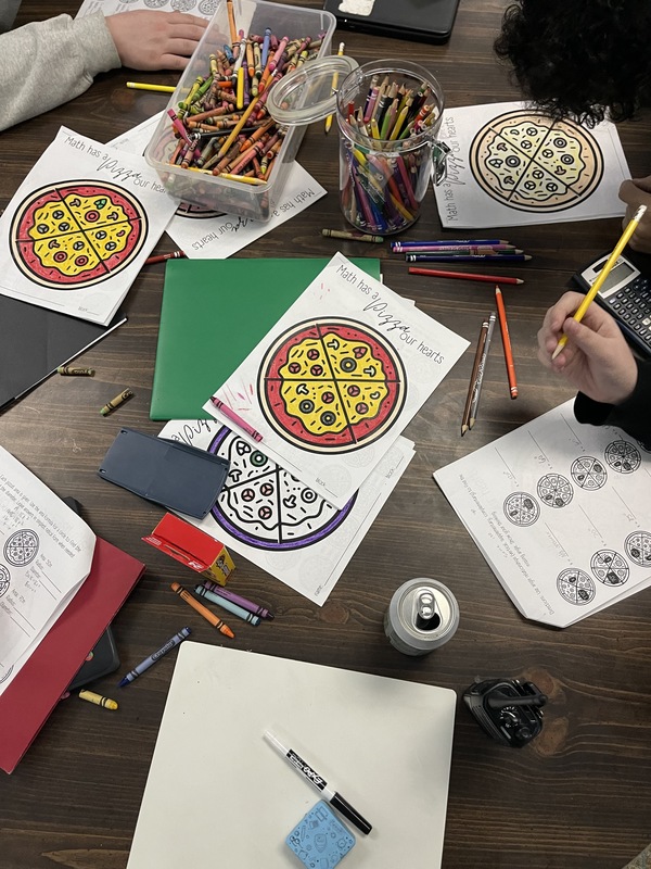 Students working on project with assorted school supplies.