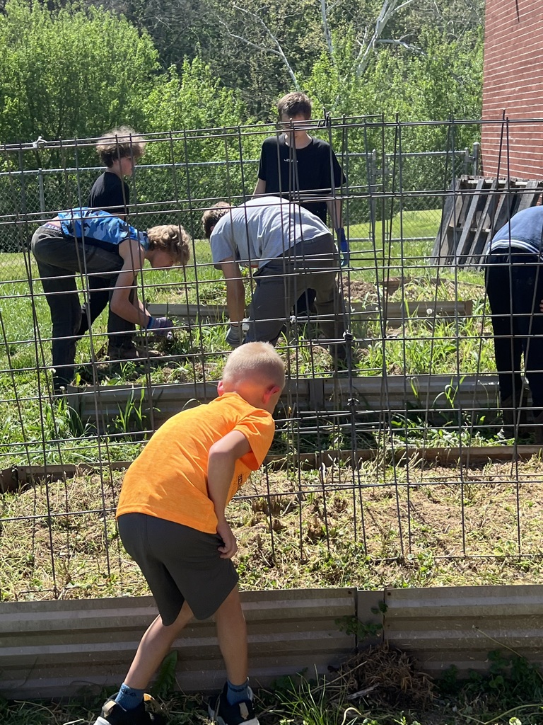 students planting and touching the dirt in the garden beds